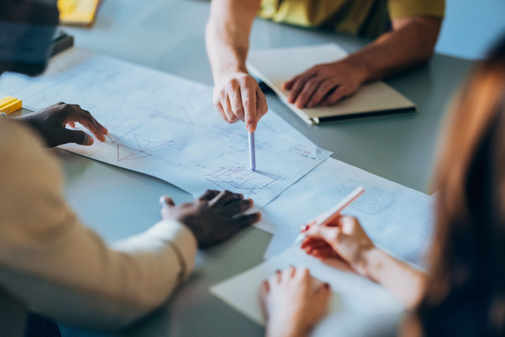 Team discussing blueprints at a table.